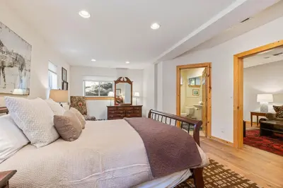 a bedroom with a bed and a living room at Trailside - Alpine Meadows 6 Bedroom with Private Hot tub in Alpine Meadows