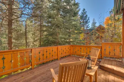 a wooden deck with two chairs and a bench at Swiss Chalet-Palisades, 6 BR, Hot Tub, Pets Ok, Ski Shuttle! in Olympic Valley