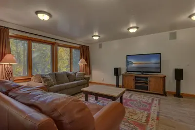 a living room with a couch and a flat screen tv at Swiss Chalet-Palisades, 6 BR, Hot Tub, Pets Ok, Ski Shuttle! in Olympic Valley
