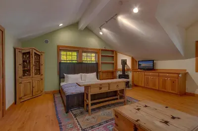a room with a bed and a desk and a tv at Swiss Chalet-Palisades, 6 BR, Hot Tub, Pets Ok, Ski Shuttle! in Olympic Valley