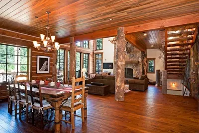 a dining room with a table and a living room at Bullshead Lodge- Luxury Estate, 4 Acres on River, Hot Tub, Minutes from the Slopes! in Olympic Valley
