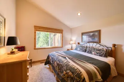 a bedroom with a bed and a desk and a window at Fawn View by Tahoe Getaways - Spacious 5 BR w Pool Table-Short Drive to Northstar in Tahoe Vista