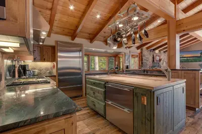 a large kitchen with wooden floors and wooden ceilings at Gray Bear Lake View Estate - Stunning Cabin w 4 Master Suites, Private Hot Tub! in Carnelian Bay