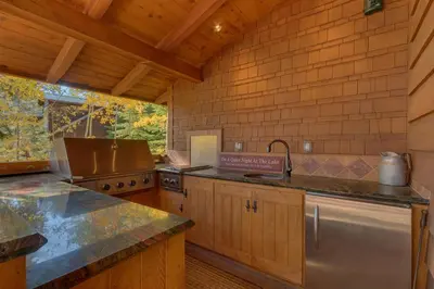 a kitchen with a stove and a sink in it at Gray Bear Lake View Estate - Stunning Cabin w 4 Master Suites, Private Hot Tub! in Carnelian Bay