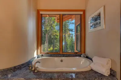 a bath tub in a room with a window at Gray Bear Lake View Estate - Stunning Cabin w 4 Master Suites, Private Hot Tub! in Carnelian Bay
