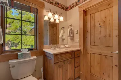 a bathroom with a toilet and a sink and a mirror at Highland Estate at Old Greenwood - Large, Luxury, Private Hot Tub & Amenity Access in Truckee