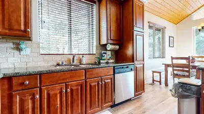 a kitchen with wooden cabinets and a sink and a table at Mammoth Gateway Village #6 condo in Mammoth Lakes