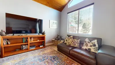 a living room with a leather couch and a flat screen tv at Mammoth Gateway Village #6 condo in Mammoth Lakes