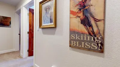 a painting hanging on a wall in a hallway at Mammoth Gateway Village #6 condo in Mammoth Lakes