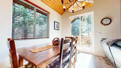 a dining room with a table and chairs and a clock at Mammoth Gateway Village #6 condo in Mammoth Lakes
