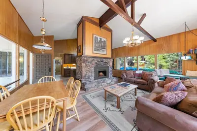 a living room with a table and a fireplace at Starry Skies on the West Shore, Private Beach, Fireplace, Pet Friendly, Close to Ski Resorts in Tahoe City
