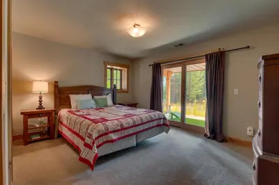 a bedroom with a bed and a large window at Summit Solitude at Palisade Tahoe - Charming 5BR w Foosball & Shuffleboard Table & Pet Friendly in Olympic Valley