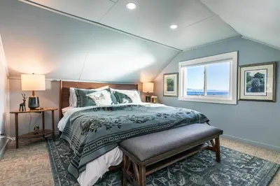 a bedroom with a large bed and a window at Beach Haven Lakefront - On a Sandy Beach with Guest House in Kings Beach