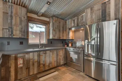 a kitchen with wooden cabinets and a stainless steel refrigerator at Above the Pines - Hot Tub- Pet Friendly -Gym and Pool Access in Truckee
