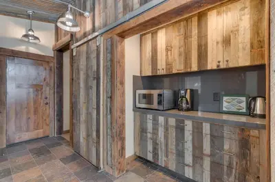 a kitchen with wooden walls and a counter with a microwave at Above the Pines - Hot Tub- Pet Friendly -Gym and Pool Access in Truckee