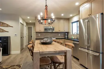 a kitchen with a wooden table and a refrigerator at Antler House- Quiet, Charming Cabin w Cozy Fireplace, Close to Skiing in Tahoe City