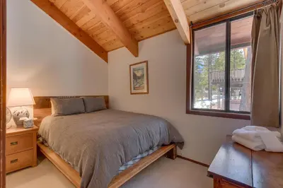 a bedroom with a bed and a window at Base Camp at Dollar Point by Tahoe Getaways - Hot Tub, Large Deck, Wood Fireplace, Short Drive to Ski Resorts! in Tahoe City