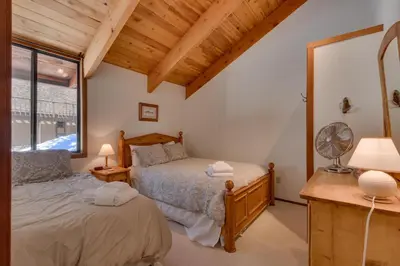 a bedroom with two beds and a window at Base Camp at Dollar Point by Tahoe Getaways - Hot Tub, Large Deck, Wood Fireplace, Short Drive to Ski Resorts! in Tahoe City
