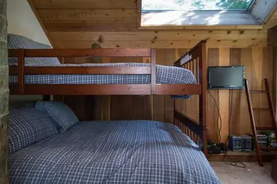 a bedroom with two bunk beds and a television at Alpine Darling- Hot Tub- Pet Friendly- 3 Minute Drive to Palisades Tahoe in Alpine Meadows