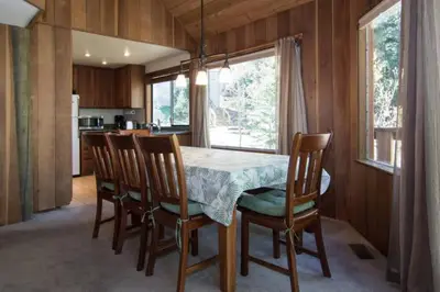 a dining room with a table and chairs and a kitchen at Alpine Darling- Hot Tub- Pet Friendly- 3 Minute Drive to Palisades Tahoe in Alpine Meadows