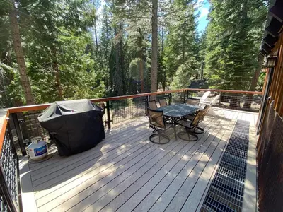 a deck with a table and a trash can at Away on Allenby by Tahoe Getaways - 3BR, Dog Ok, Close to Northstar! in Tahoe Vista
