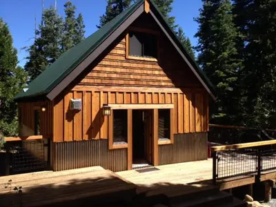 a small wooden cabin with a door on a deck at Away on Allenby by Tahoe Getaways - 3BR, Dog Ok, Close to Northstar! in Tahoe Vista