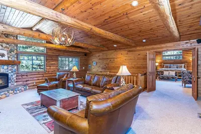 a living room with leather furniture and a fireplace at 1138 Lakeshore - One-of-a-kind Lakeshore Boulevard log cabin in Incline Village
