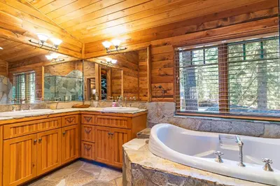 a bathroom with a tub and two sinks at 1138 Lakeshore - One-of-a-kind Lakeshore Boulevard log cabin in Incline Village