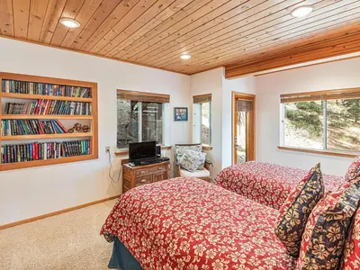 a bedroom with two beds and a book shelf at Fantastic Lakeview house with large decks! in Incline Village