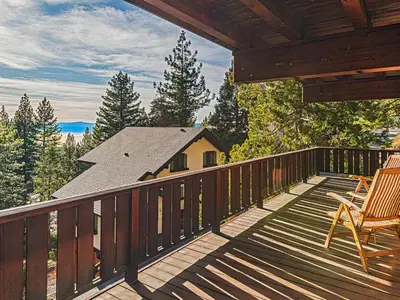 a deck with two chairs and a house at Fantastic Lakeview house with large decks! in Incline Village