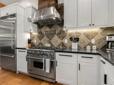 a kitchen with white cabinets and a stainless steel stove at Modern Millcreek Home in Incline Village