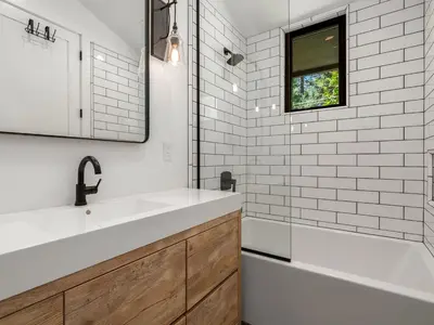 a bathroom with a sink and a tub and a mirror at Modern Millcreek Home in Incline Village