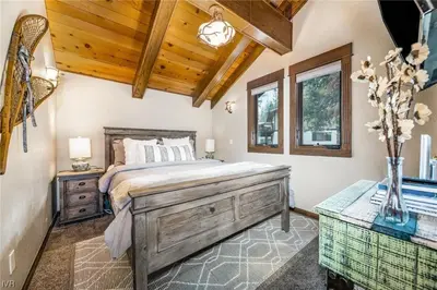 a bedroom with a large bed and a wooden ceiling at 1331 Zurich Lane - Modern Mountain Chalet in Incline Village