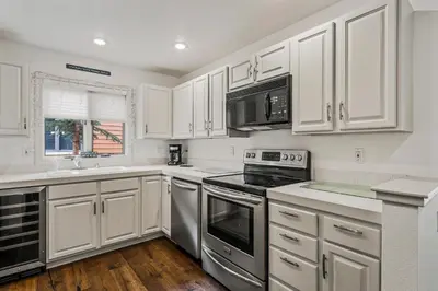 a kitchen with white cabinets and stainless steel appliances at 153 McCloud The perfect location! Enjoy the sun drenched deck in Incline Village