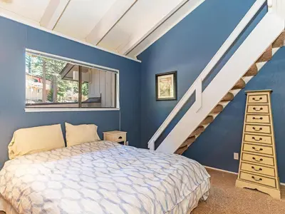 a blue bedroom with a bed and a staircase at Mountain Shadows #172 - - pool in Incline Village