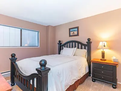 a bedroom with a black bed and a window at Mountain Shadows #172 - - pool in Incline Village