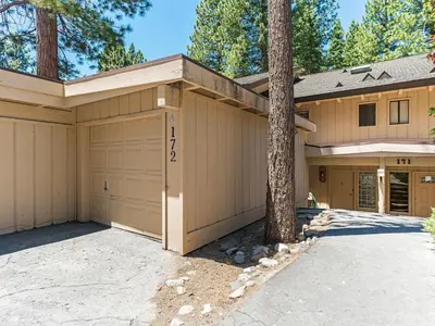 a house with two garage doors and a tree at Mountain Shadows #172 - - pool in Incline Village