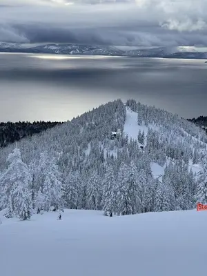 a mountain covered in snow with trees and water at New renovated McCloud Condo in the middle of Town in Incline Village