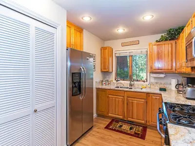 a kitchen with wooden cabinets and a stainless steel refrigerator at The McCloud Condominium complex is one of the most popular vacation rentals in Incline Village