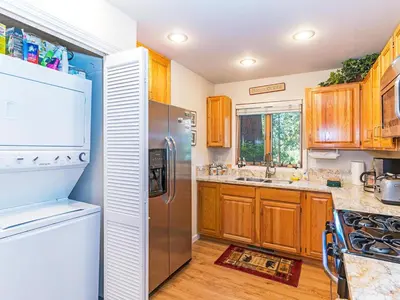 a kitchen with wooden cabinets and a stainless steel refrigerator at The McCloud Condominium complex is one of the most popular vacation rentals in Incline Village