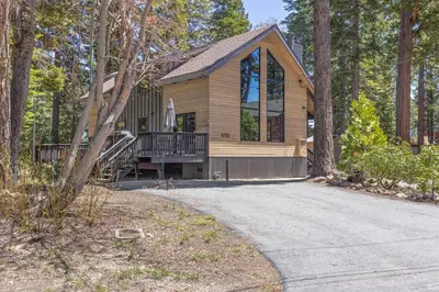 a house in the woods with a driveway at Four Summits- Hot Tub- Pool Table- Short Drive to Ski Resorits in Carnelian Bay