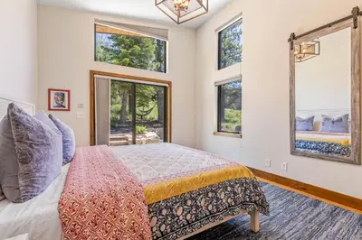 a bedroom with a bed in a room with windows at Harmony at Tahoe Donner - Ultra Modern 4 BR, Hot Tub, Game Room, Amenity Access in Truckee