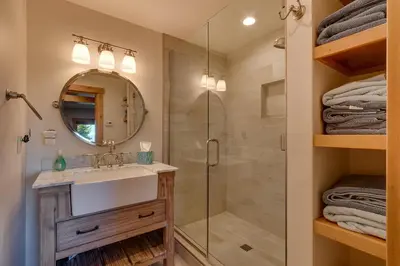 a bathroom with a shower and a sink and a mirror at Huckleberry Haven by Tahoe Getaways - Luxury Lake View 4BR in North Lake with Private Hot Tub in Carnelian Bay