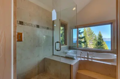 a bathroom with a tub and a sink and a window at Huckleberry Haven by Tahoe Getaways - Luxury Lake View 4BR in North Lake with Private Hot Tub in Carnelian Bay