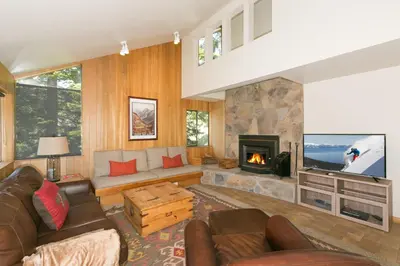 a living room with a couch and a fireplace at Juniper at Alpine - Private Hot tub, Pet Friendly & Free Shuttle to Slopes in Olympic Valley