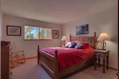 a bedroom with a bed with red sheets and a window at Lake Haven at Dollar Point - Spacious 4 BR w Lake Views, Sauna, Near Ski Resorts! in Tahoe City