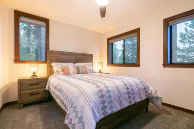 a bedroom with a bed and two windows at Lake of the Sky at Dollar Point - Stunning 4BR,4BA w Lake Views, Hot Tub and Pet-friendly in Tahoe City