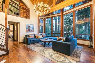 a living room with blue couches and a chandelier at Lake of the Sky at Dollar Point - Stunning 4BR,4BA w Lake Views, Hot Tub and Pet-friendly in Tahoe City