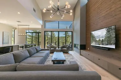 a living room with a large couch and a tv at Larkspur Luxe at Northstar- 4 BR with Pool, Gym, Access - Walk to Village, Private Hot Tub in Truckee