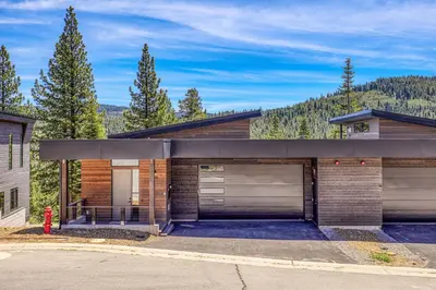 a house with two garage doors and a fire hydrant at Larkspur Luxe at Northstar- 4 BR with Pool, Gym, Access - Walk to Village, Private Hot Tub in Truckee